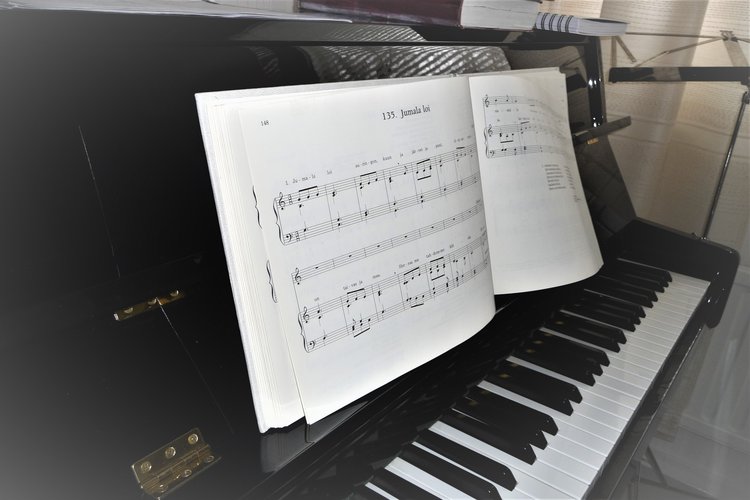Kuva pianosta ja nuottikirjasta